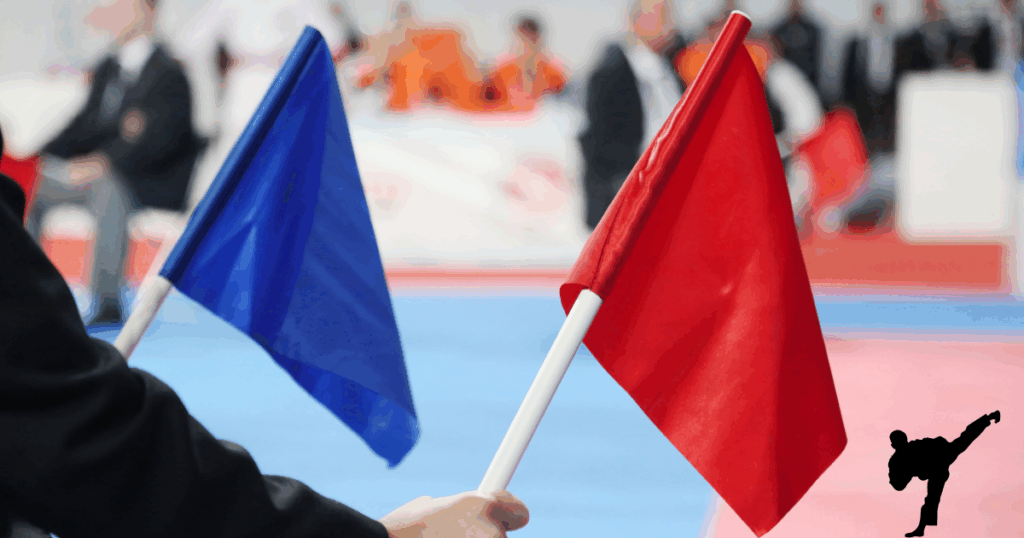 空手試合の審判が左手に青右手に赤の旗を持つ画像